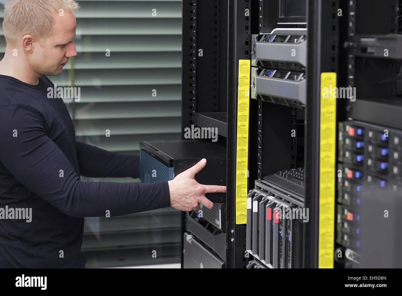 IT-Techniker / Berater installieren / fügt einen Router / switch in einem Rack. Gedreht in einem Rechenzentrum. Stockfoto