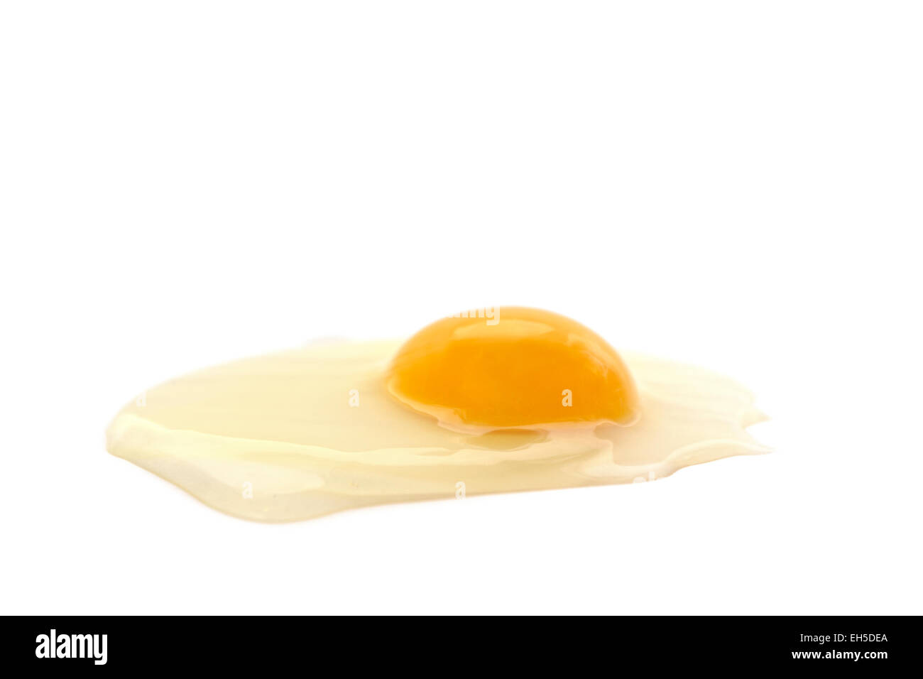 Seitlicher Blick auf eine Bio-rissige Ei mit Eiweiß und Eigelb auf weißem Hintergrund. Stockfoto