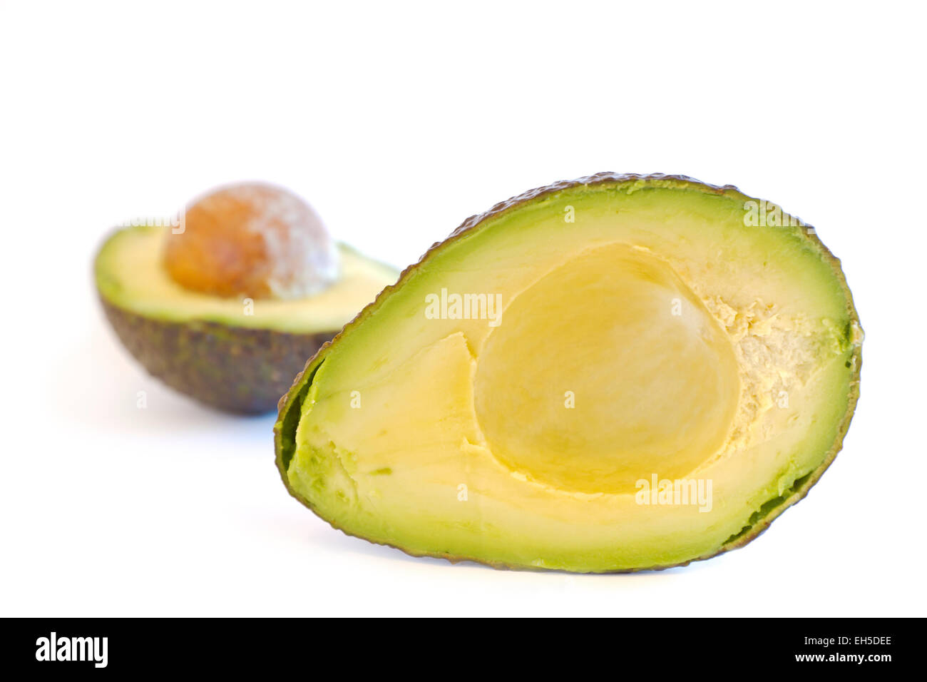 Seitenansicht einer gesplitteten Bio Avocado mit Stein auf weißem Hintergrund. Stockfoto