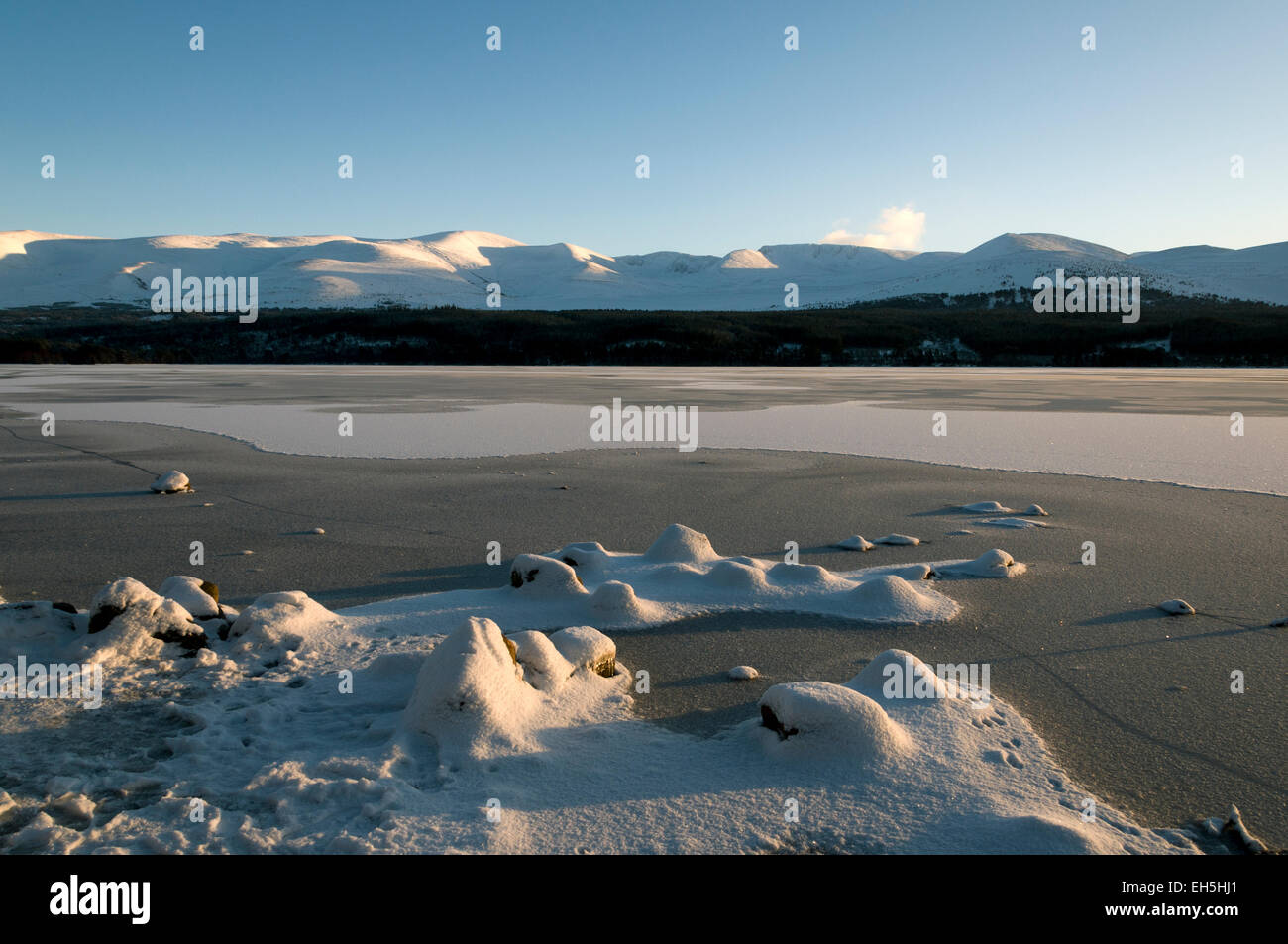 Die Cairngorm Berge über einen gefrorenen Loch Morlich, in der Nähe von Aviemore Highland Region, Schottland, UK Stockfoto