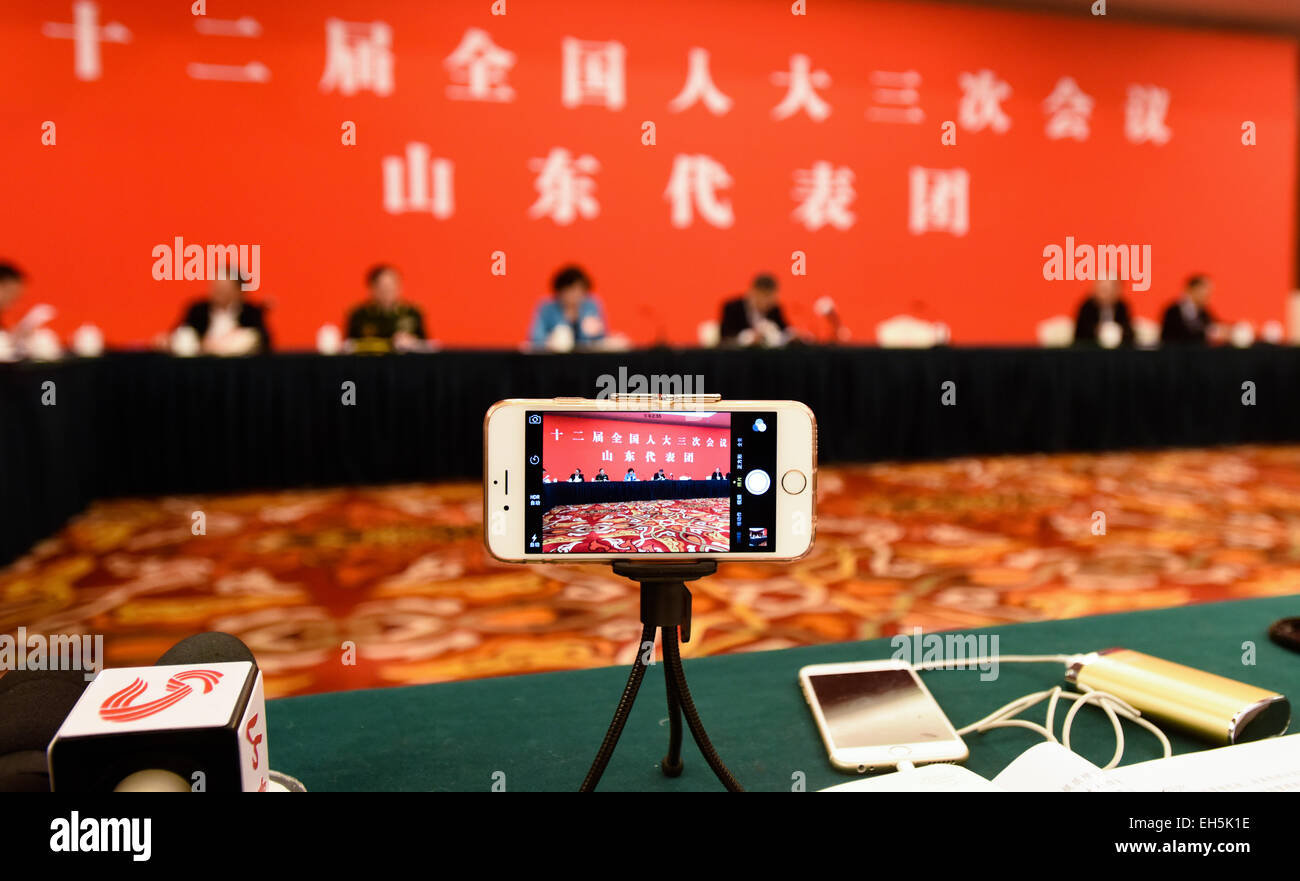 (150307)--Peking, 7. März 2015 (Xinhua)--ein Journalist nutzt ein Handy und ein Mini-Stativ schießen Videos während einer eine Podiumsdiskussion der Abgeordnetenkammer zu Chinas 12. nationalen Volksarmee Kongress (NPC) aus der ostchinesischen Provinz Shandong in Peking, Hauptstadt von China, 7. März 2015. (Xinhua/Wang Jianhua) (Yxb) Stockfoto