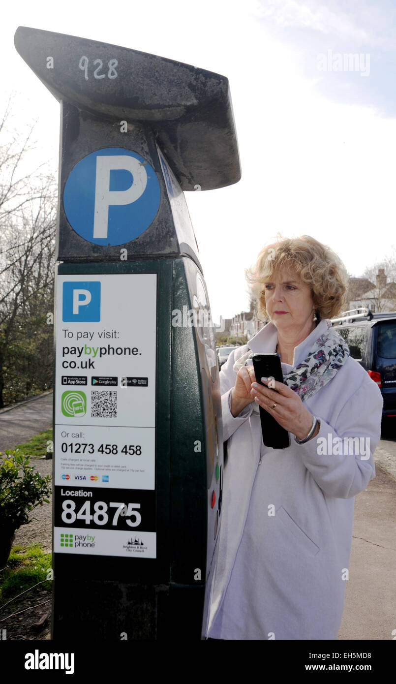 Weibliche Fahrer zahlt für die Parkuhr mit einem Paybyphone Handy-app in  Brighton UK Stockfotografie - Alamy