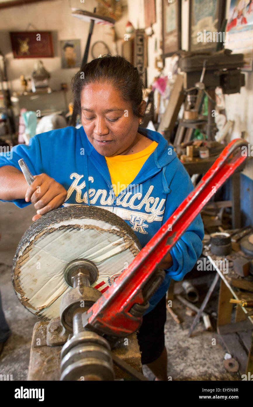 Arbeiter de Morelos, Oaxaca, Mexiko - ändert eine Frau die Schleifscheibe auf einer Schleifmaschine, die bei der Herstellung von handgemachten Messern verwendet. Stockfoto