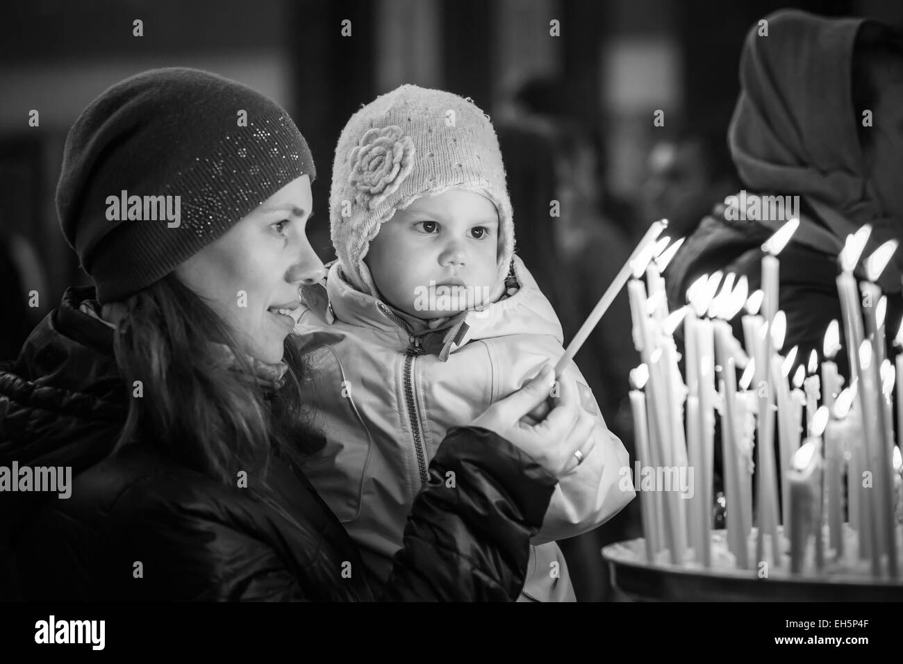 Mutter und ihrer kleinen blonden kaukasischen Tochter mit Kerzen in Russisch-Orthodoxen Kirche. Schwarz / weiß Foto Stockfoto