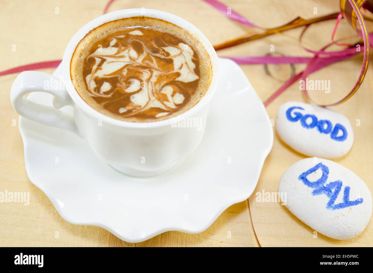 Weiße Tasse Kaffee mit dekorierten Schaum und Felsen sagen: "Guten Tag" Stockfoto