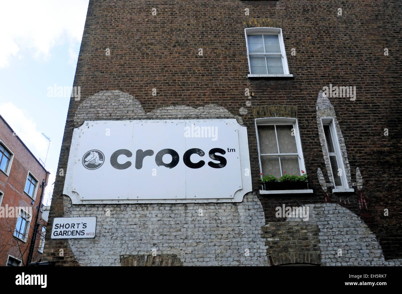 Crocs Schild an Wand mit Shorts Garden WC2 Straßenschild unterhalb und eine Auswahl von Fenstern, Covent Garden, London England Großbritannien U Stockfoto