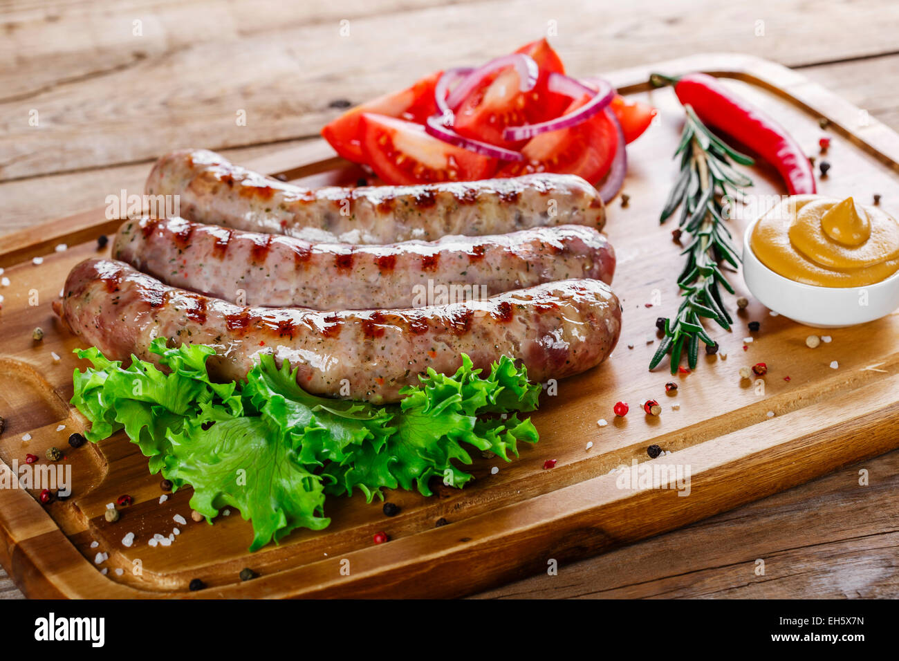 Gegrillte Würstchen mit auf ein Schneidebrett Stockfoto