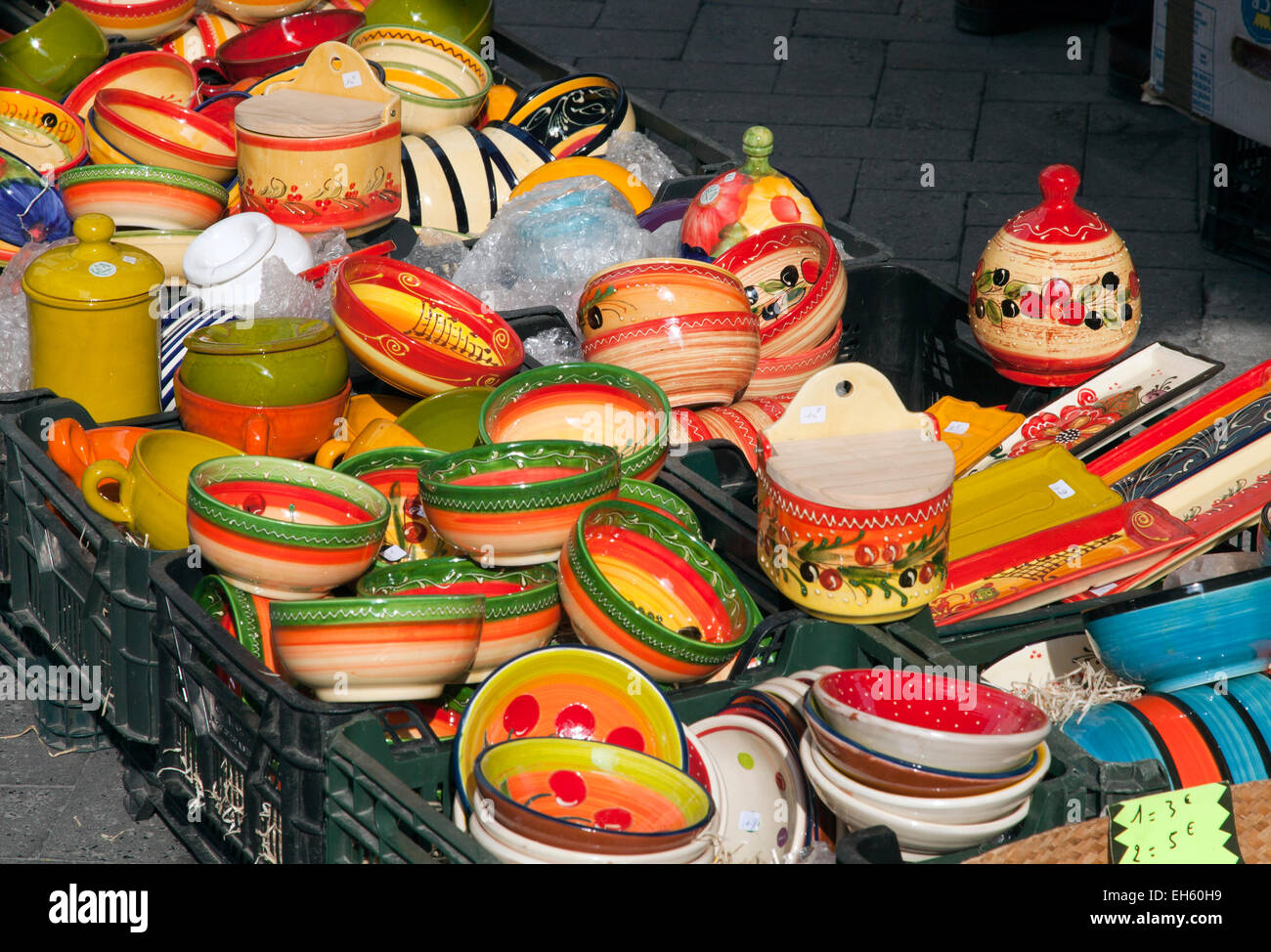Typische Provencals Keramik, Vintage-Kleidung, Spielzeug, Lebensmittel und Antiquitäten teilen Bürgersteige an Markttagen in L'Isle-Sur-la-Sorgue. Stockfoto