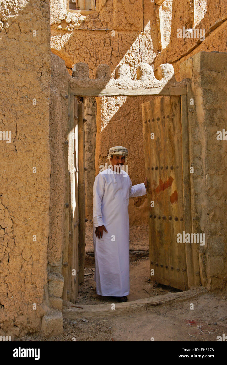 Mann in der Tür des alten Lehmziegeln bauen, Al-Hamra, Oman Stockfoto