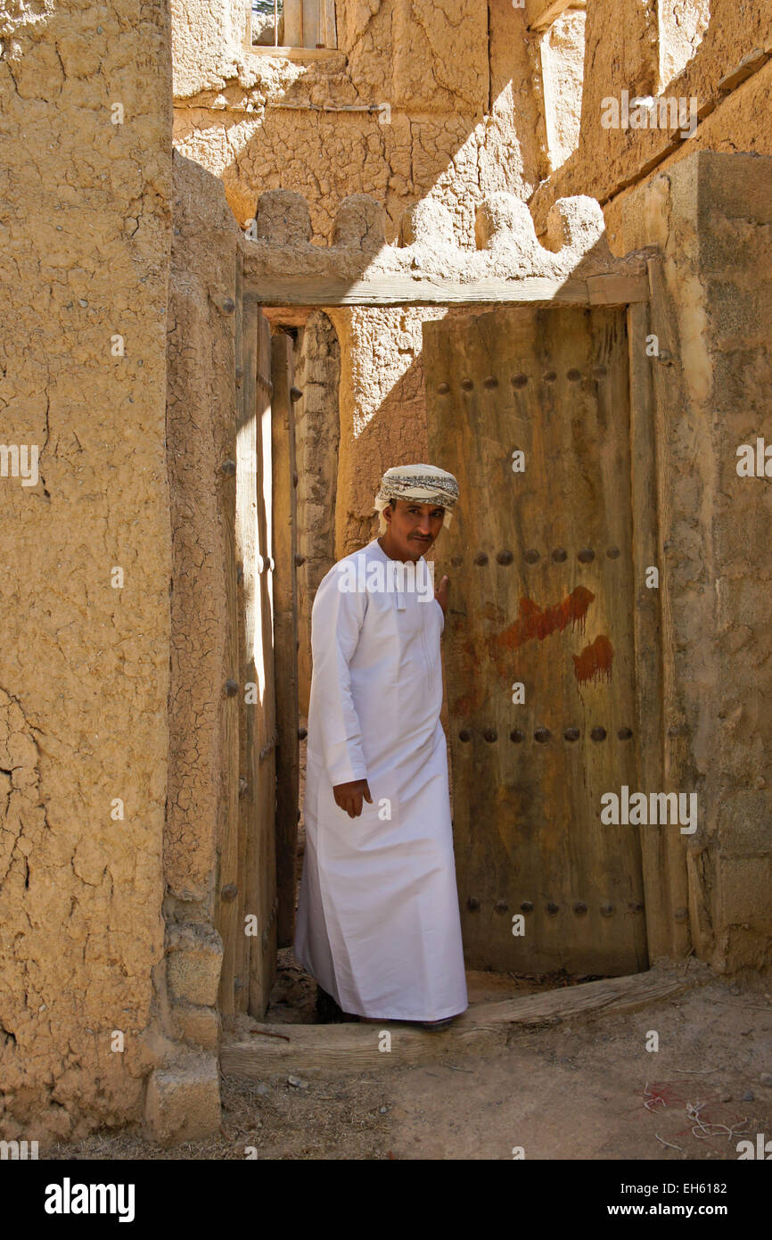 Mann in der Tür des alten Lehmziegeln bauen, Al-Hamra, Oman Stockfoto