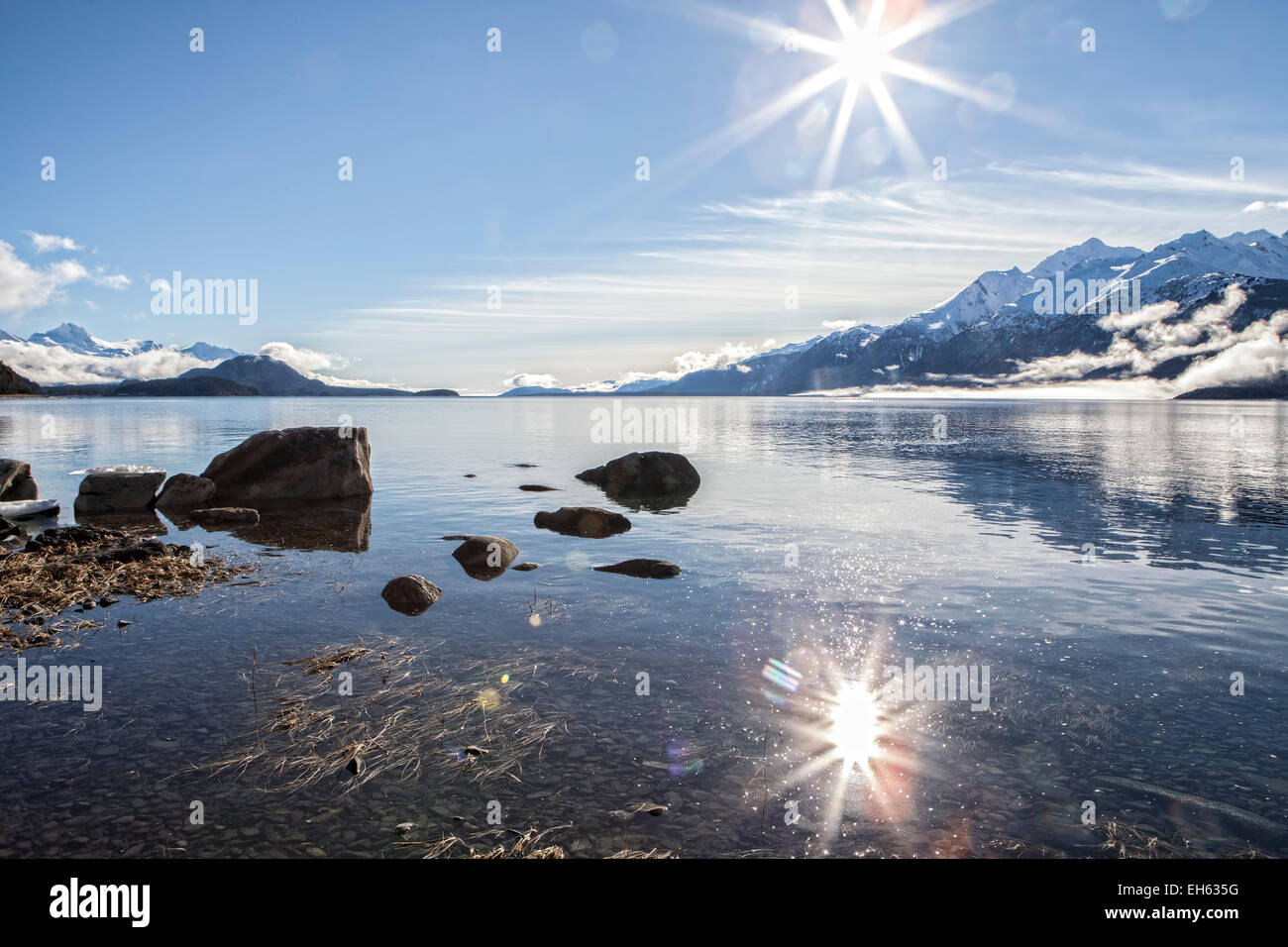 Sunburst über ein Südosten Alaskas Fjord mit Reflexionen und magische funkelt im Wasser. Stockfoto