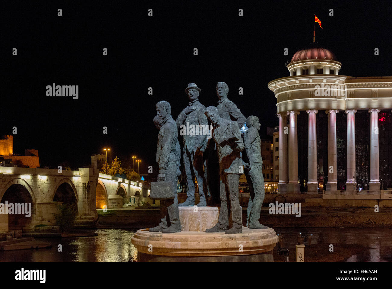 Statuen mit Blick auf das archäologische Museum von Mazedonien & steinerne Brücke in der Nacht, Skopje Stockfoto