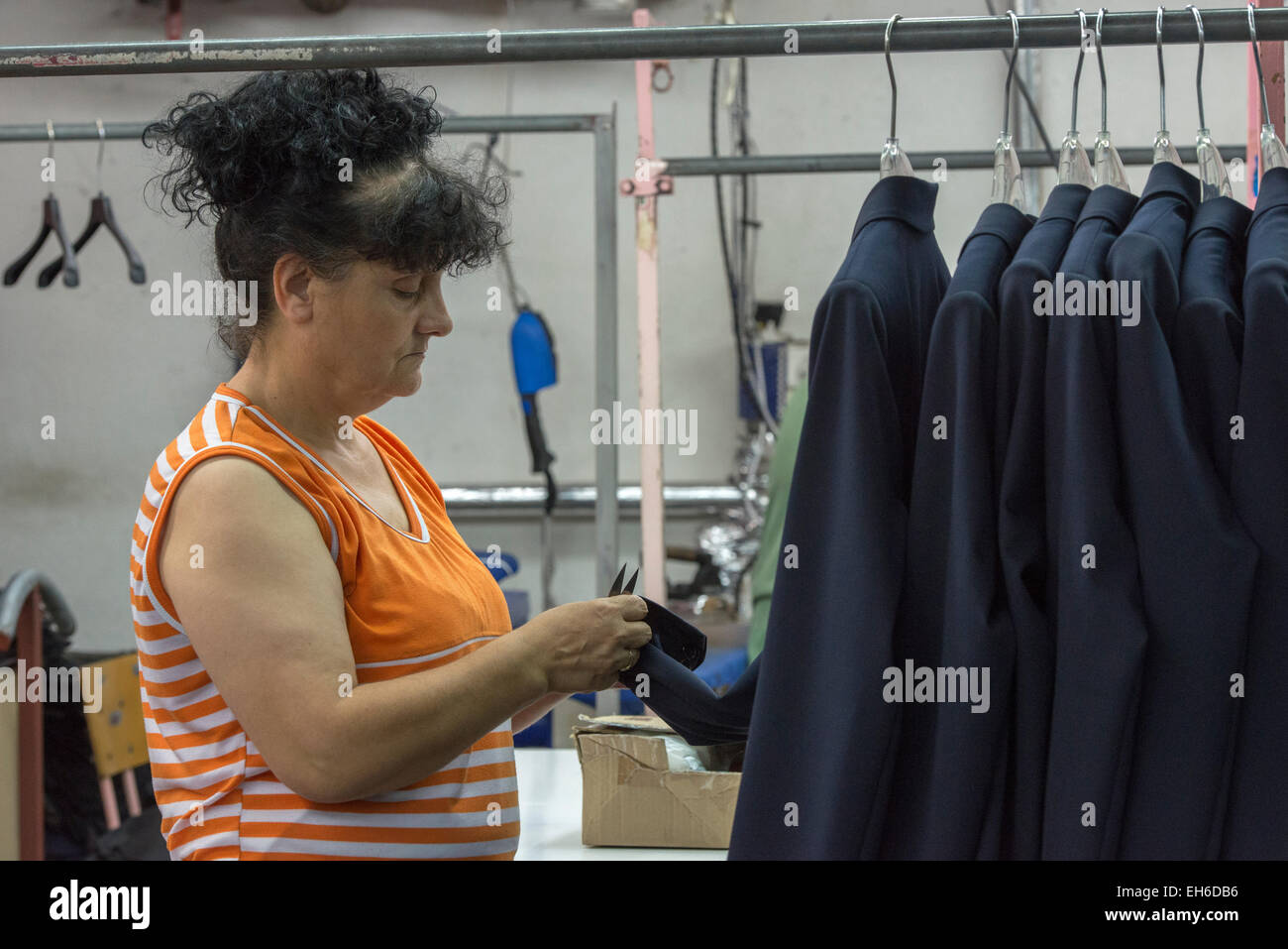 Arbeitnehmerin überprüfen Jacken auf Kleiderbügeln, Astibo Kleidfabrik, Štip Stockfoto