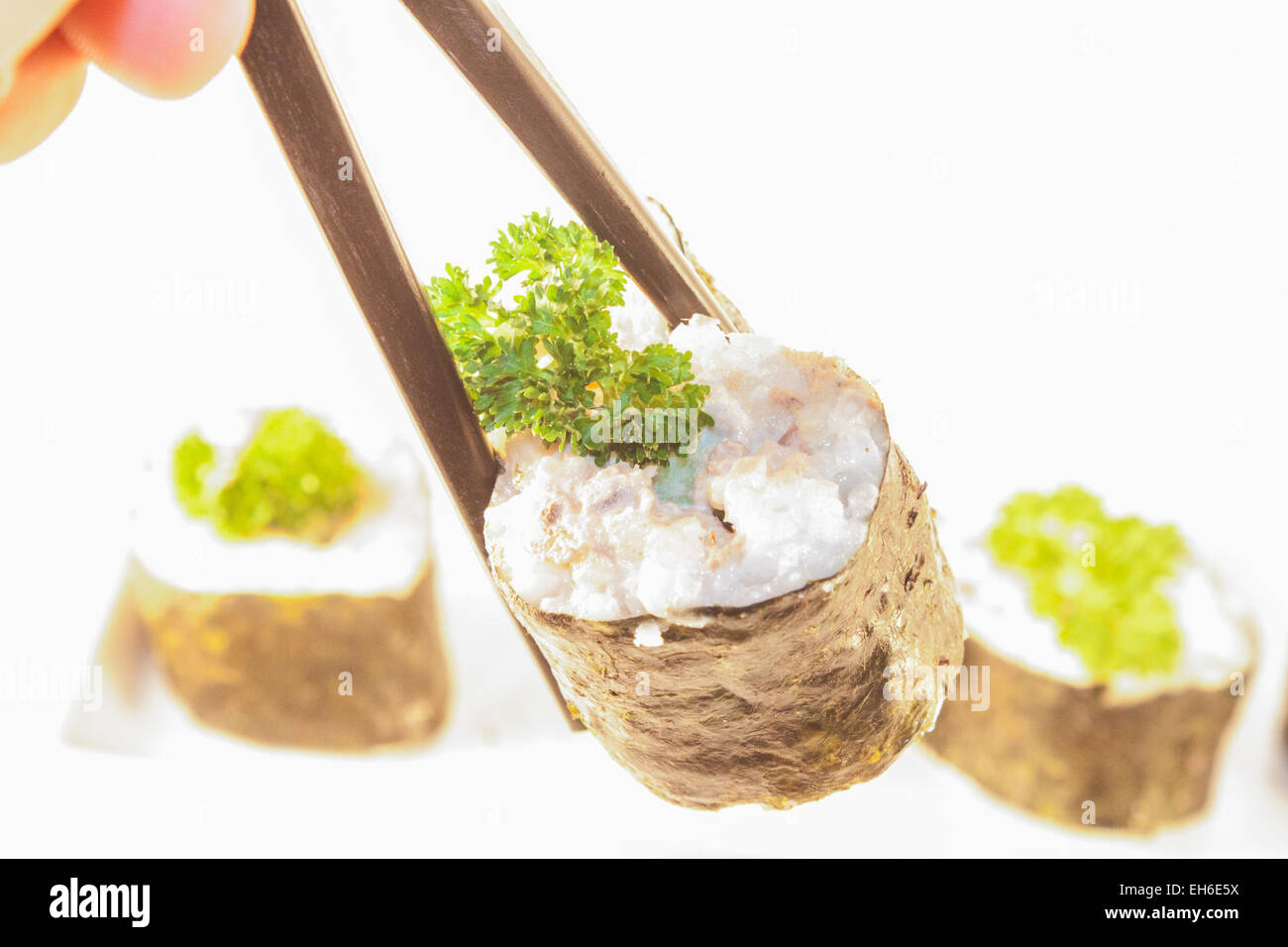 Eine leckere Sushi-Rolle, zwischen Sushi Stöcken. Isoliert auf weißem Hintergrund Stockfoto