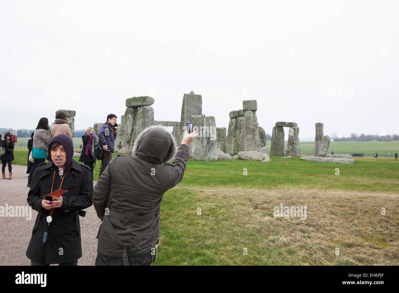 Touristen fotografieren mit Telefon er Monument Stonehenge, England Stockfoto