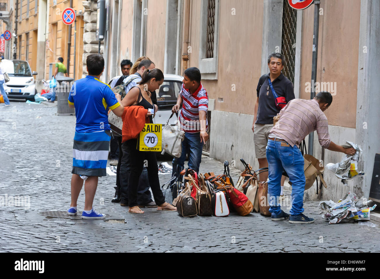 Schnäppchenjäger suchen bei Damen Handtaschen in einer Seitenstraße in Rom, Italien. Stockfoto
