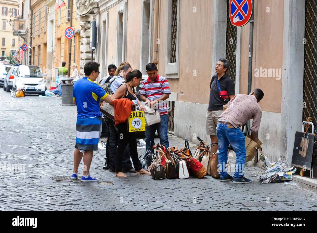 Schnäppchenjäger suchen bei Damen Handtaschen in einer Seitenstraße in Rom, Italien. Stockfoto