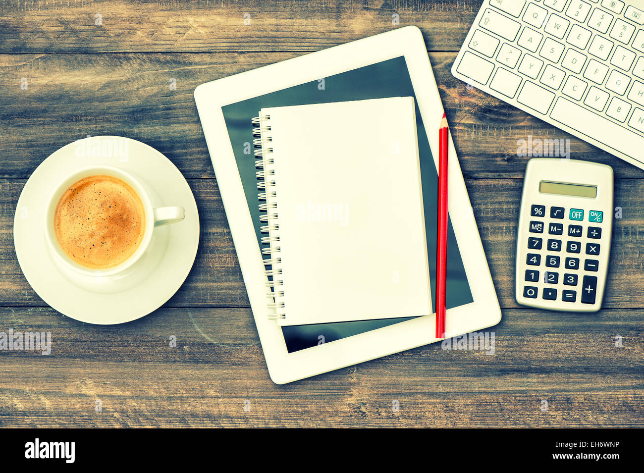 Home-Office-Arbeitsplatz. Arbeitsplatz mit digitalen Tablet-pc, Tastatur und Tasse Kaffee am Tisch aus Holz. Stockfoto