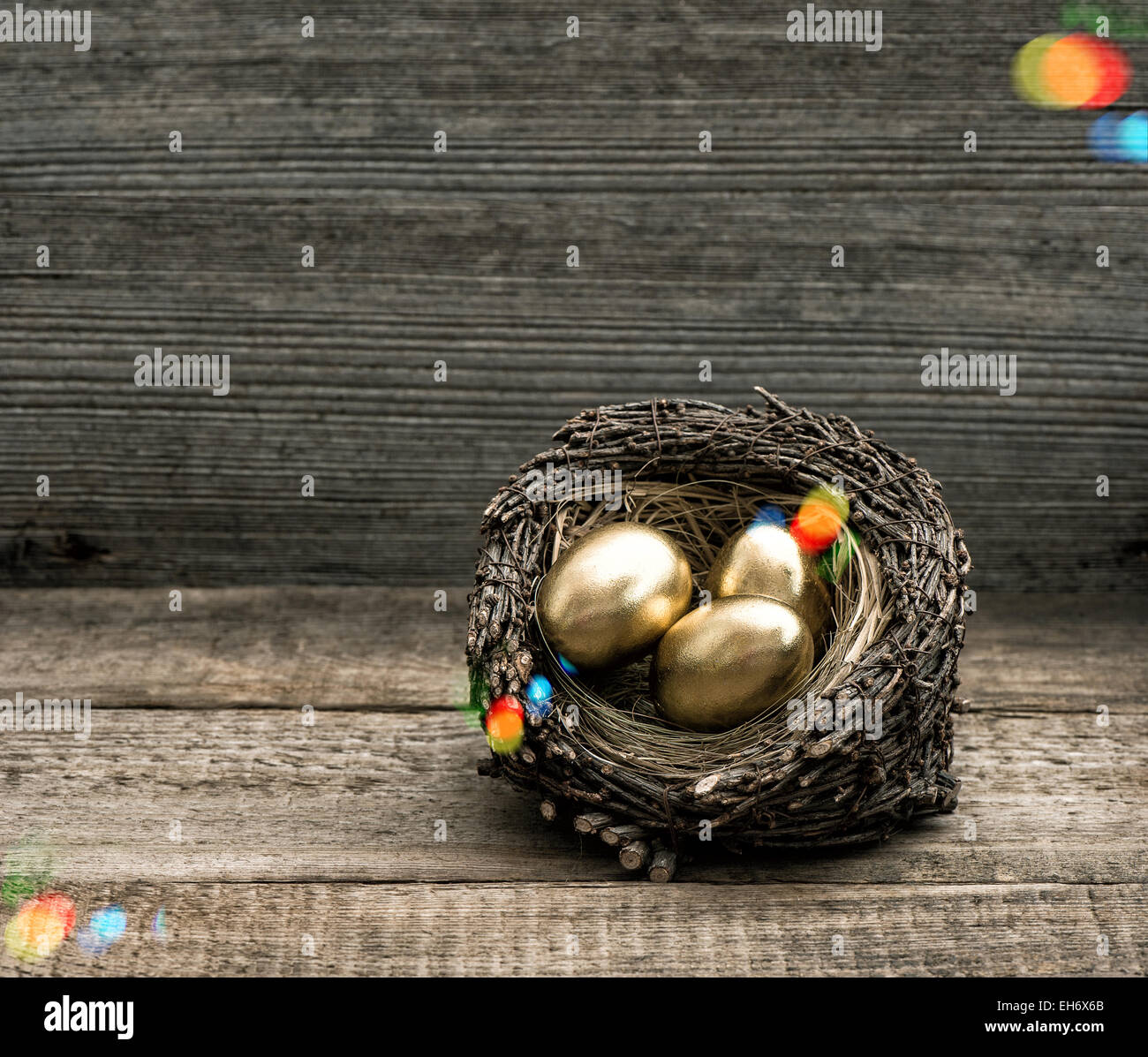 Goldene Ostereier im Nest auf Vintage rustikales Holz-Hintergrund. Festlichen Stillleben. Retro-Stil getönten Bild mit lichtdicht Stockfoto