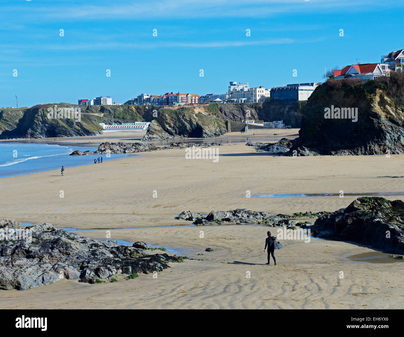 Mann, der am Strand mit Surfbrett läuft, Newquay, Cornwall, England Stockfoto