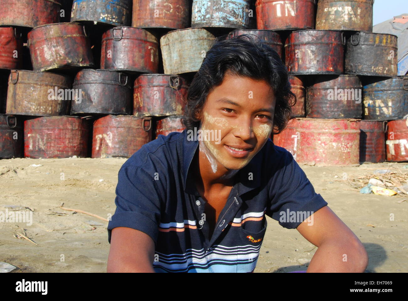 Jungen Mann vor Metallbehälter, Mandalay, Banken des Ayeyarwady Fluss Stockfoto
