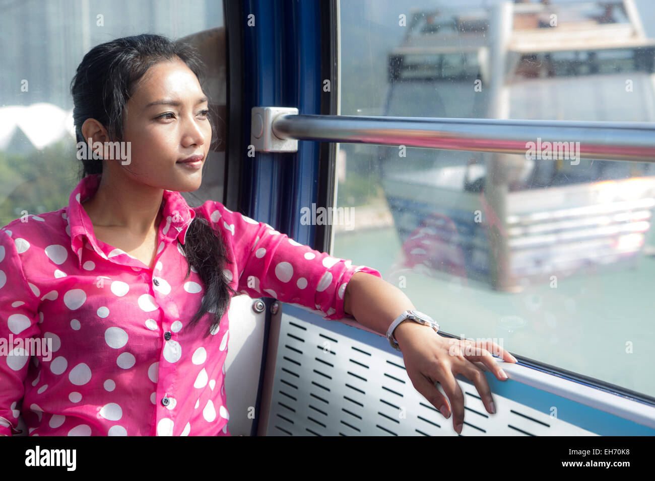 Eine Frau fährt mit der Seilbahn und schaut aus dem Fenster Stockfoto