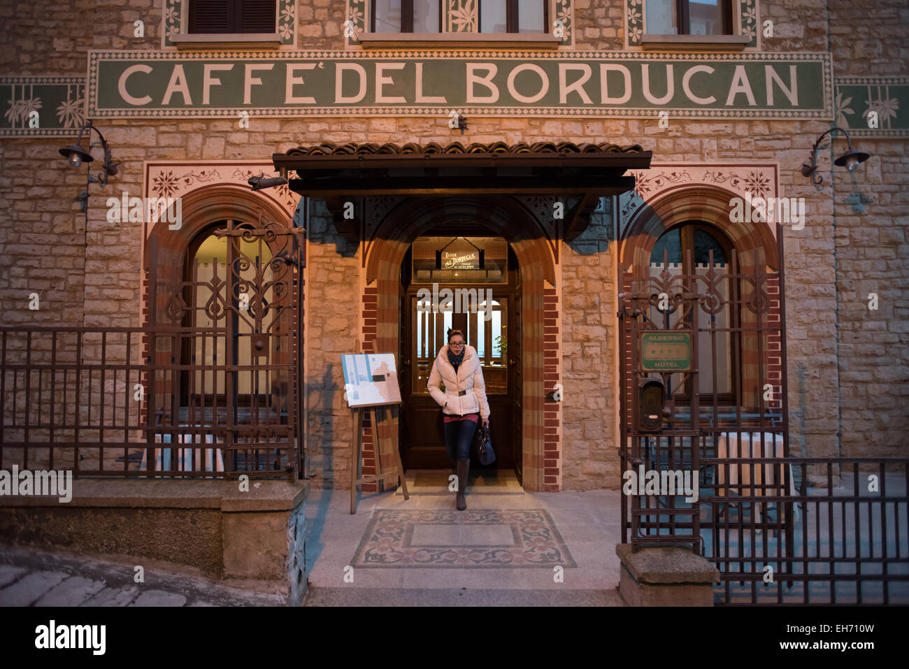Eine Frau kommt aus Caffè del Borducan in Santa Maria del Monte in der Nähe von Varese, Italien Stockfoto