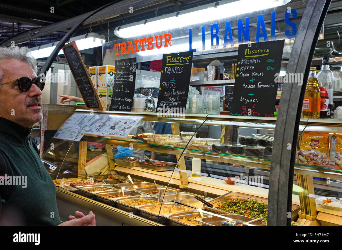 Ein Mann studiert die Speisekarte in einem libanesischen Restaurant in Le Marché des Enfants Rouges Paris. Stockfoto