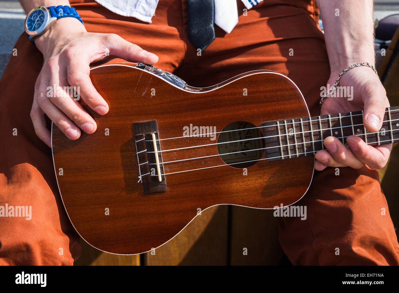 Nicht identifizierte unkenntlich junge männliche Person hält Hawaii-Gitarre Ukulele in seinen Händen. Stockfoto