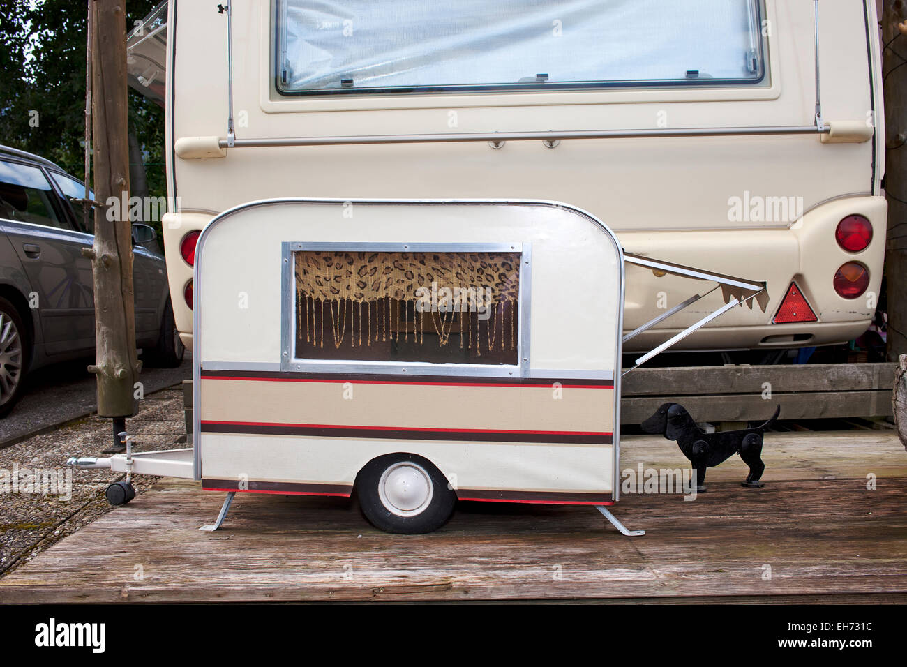Kleines Modell Wohnwagen für einen kleinen Hund geparkt auf der Rückseite  der Eigentümer in voller Größe Wohnwagen auf einem Campingplatz  Stockfotografie - Alamy