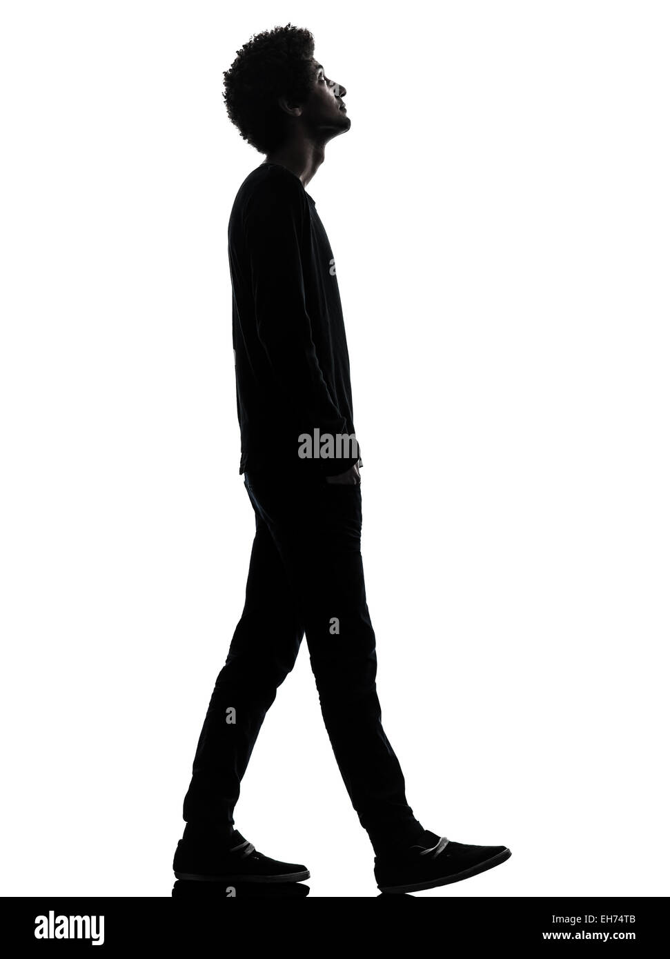 eine afrikanische hübscher junger Mann zu Fuß auf der Suche im Silhouette Studio isoliert auf weißem Hintergrund Stockfoto
