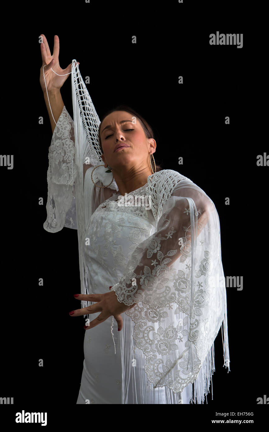 Flamenco-Tänzerin mit weißen Kleid Rücken und Hände gekreuzt auf schwarzem Hintergrund Stockfoto