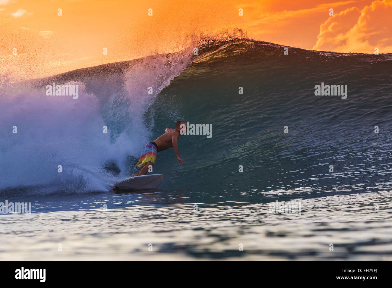 Surfen Sie eine Welle bei Sonnenuntergang. Stockfoto