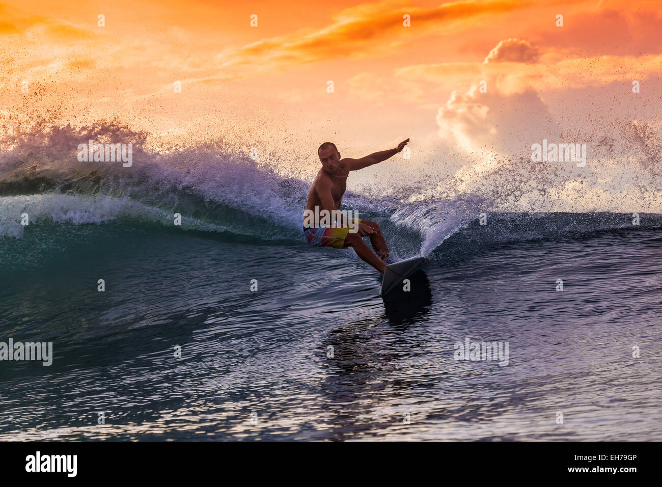 Surfen Sie eine Welle bei Sonnenuntergang. Stockfoto