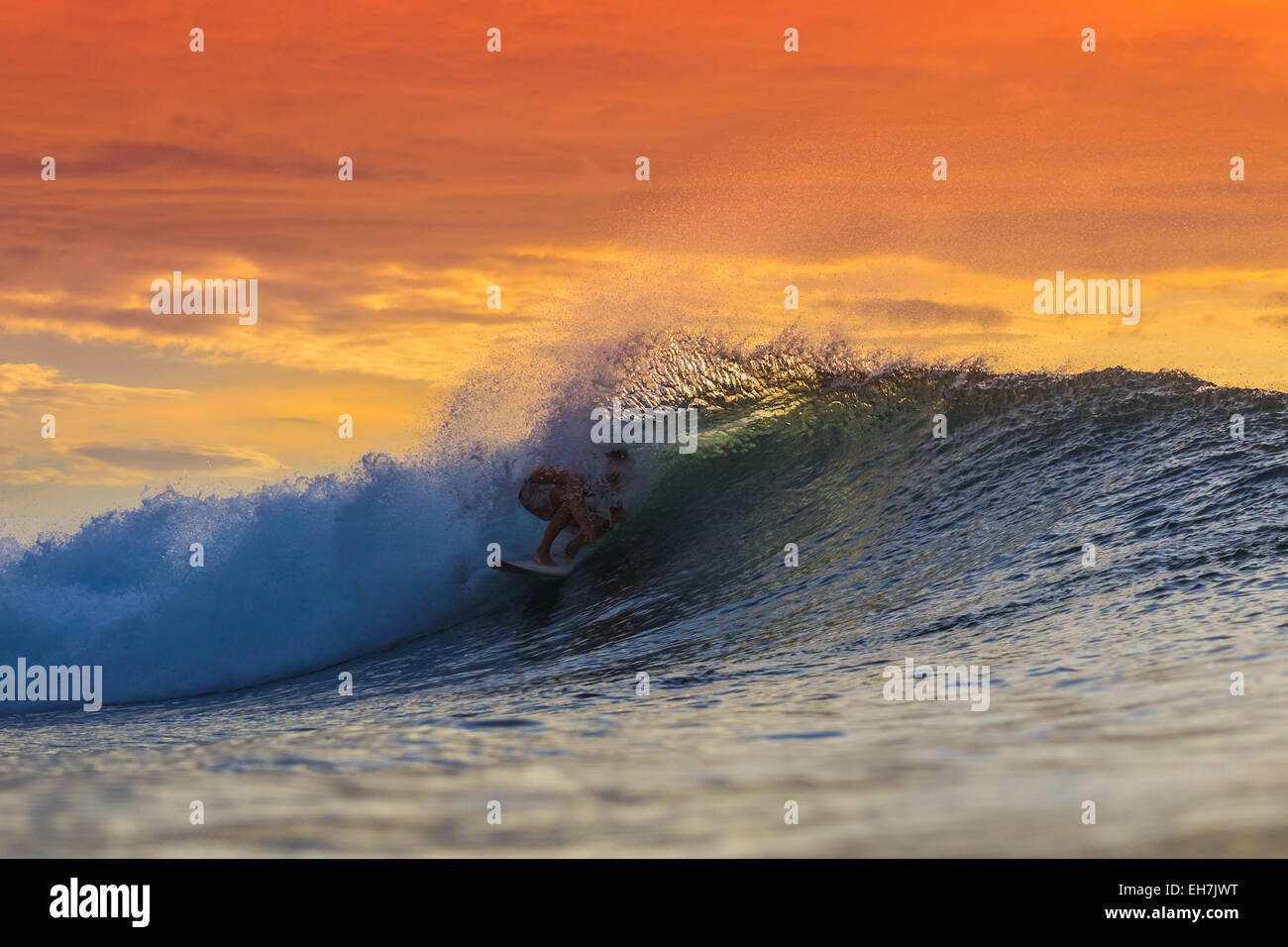 Surfen bei Sonnenuntergang. Stockfoto
