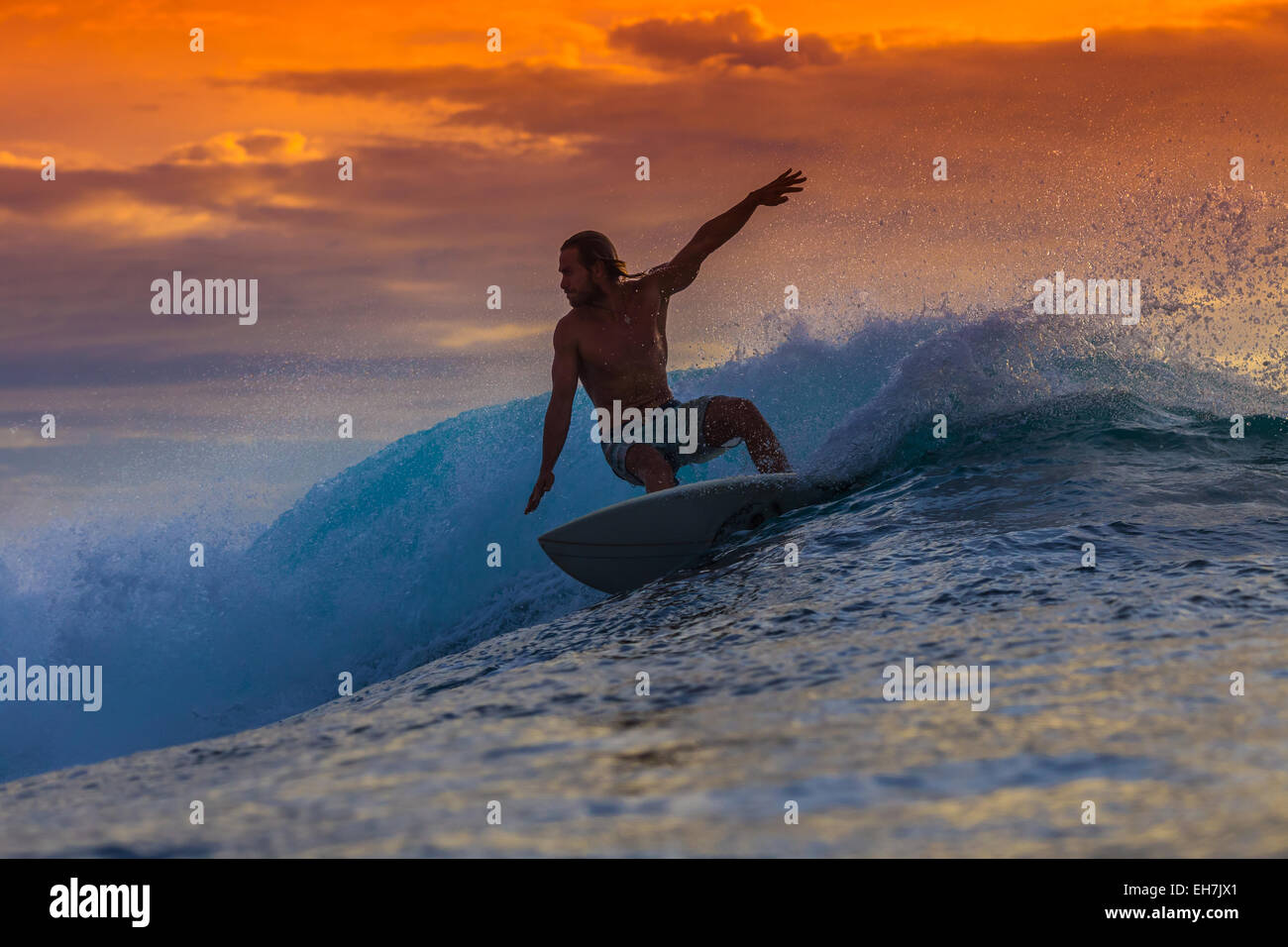 Surfen bei Sonnenuntergang. Stockfoto