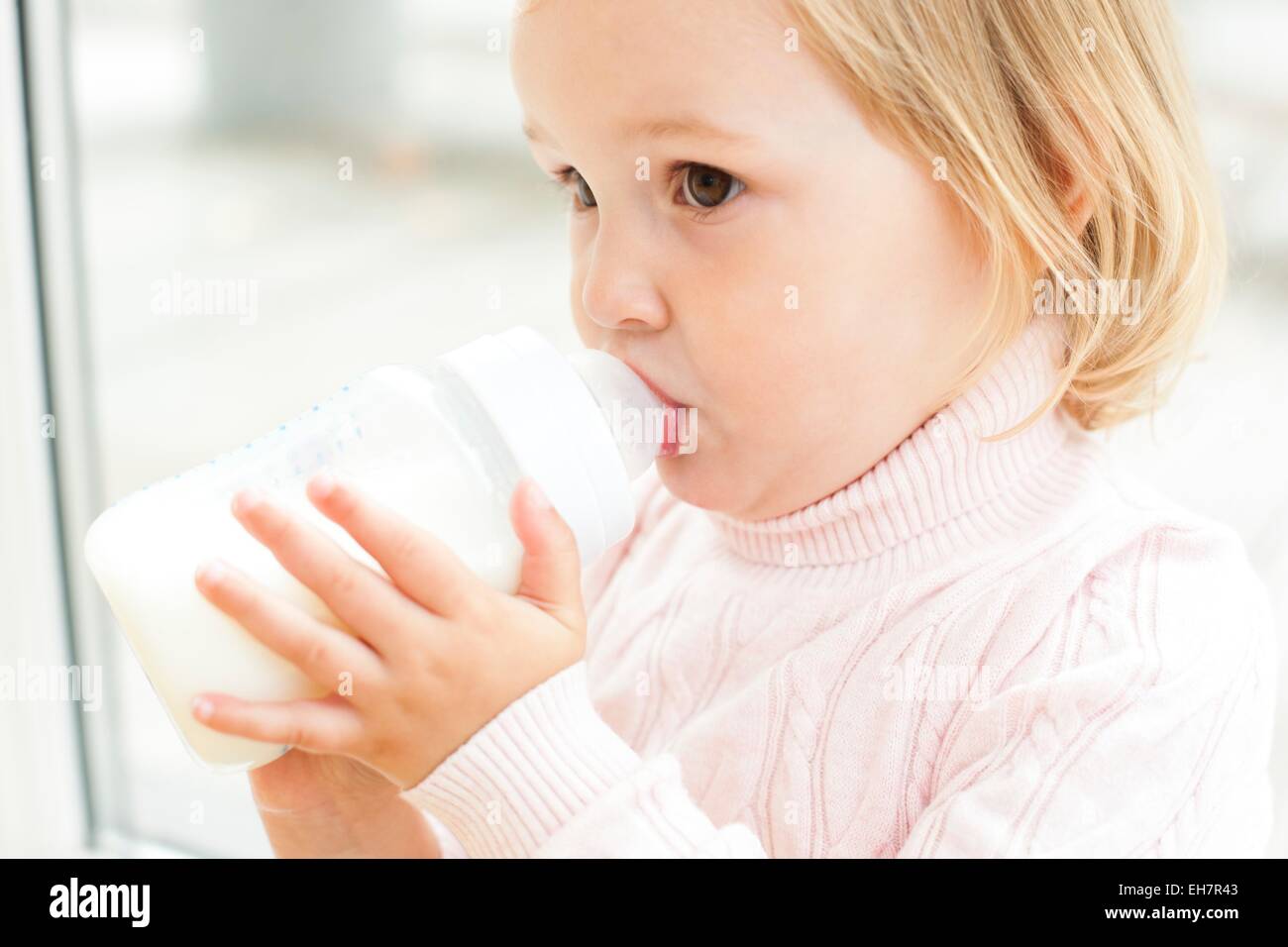 Kleinkind mit einer Flasche Milch Stockfoto