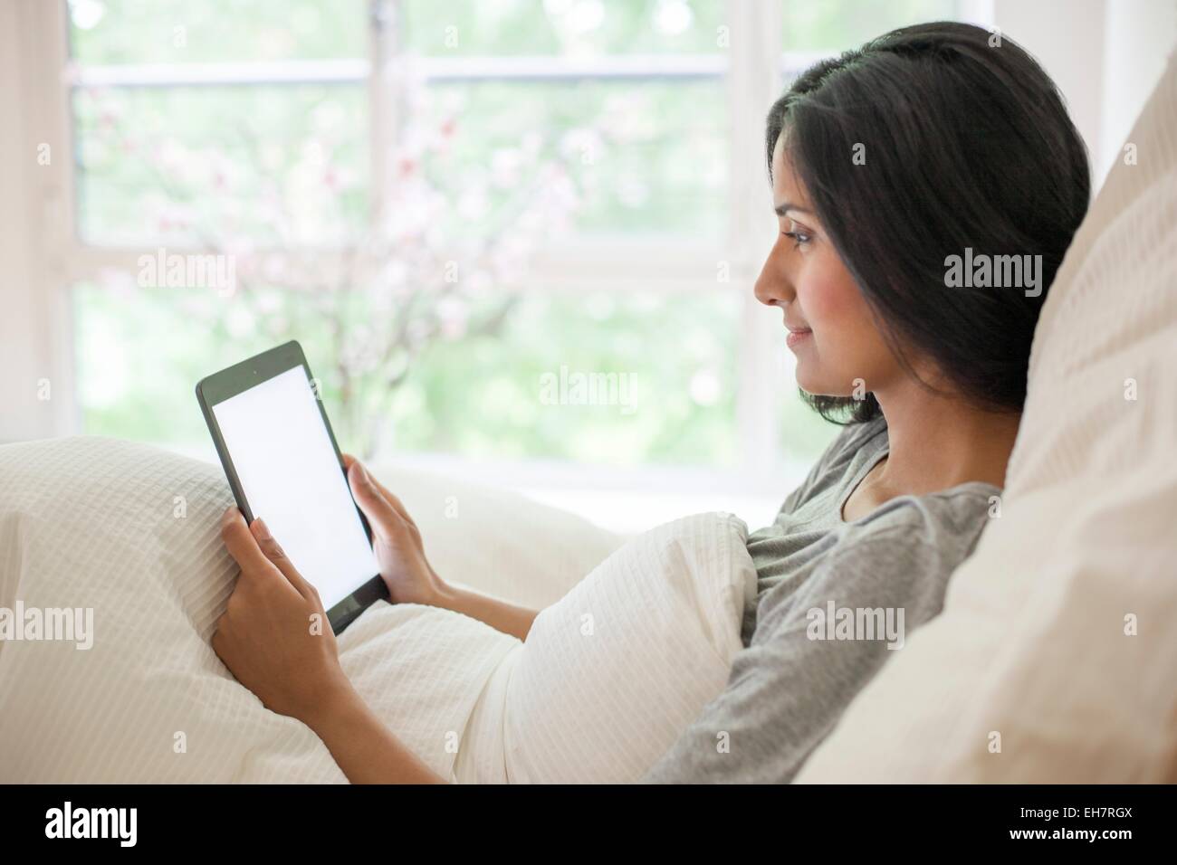 Frau im Bett mit digital-Tablette Stockfoto