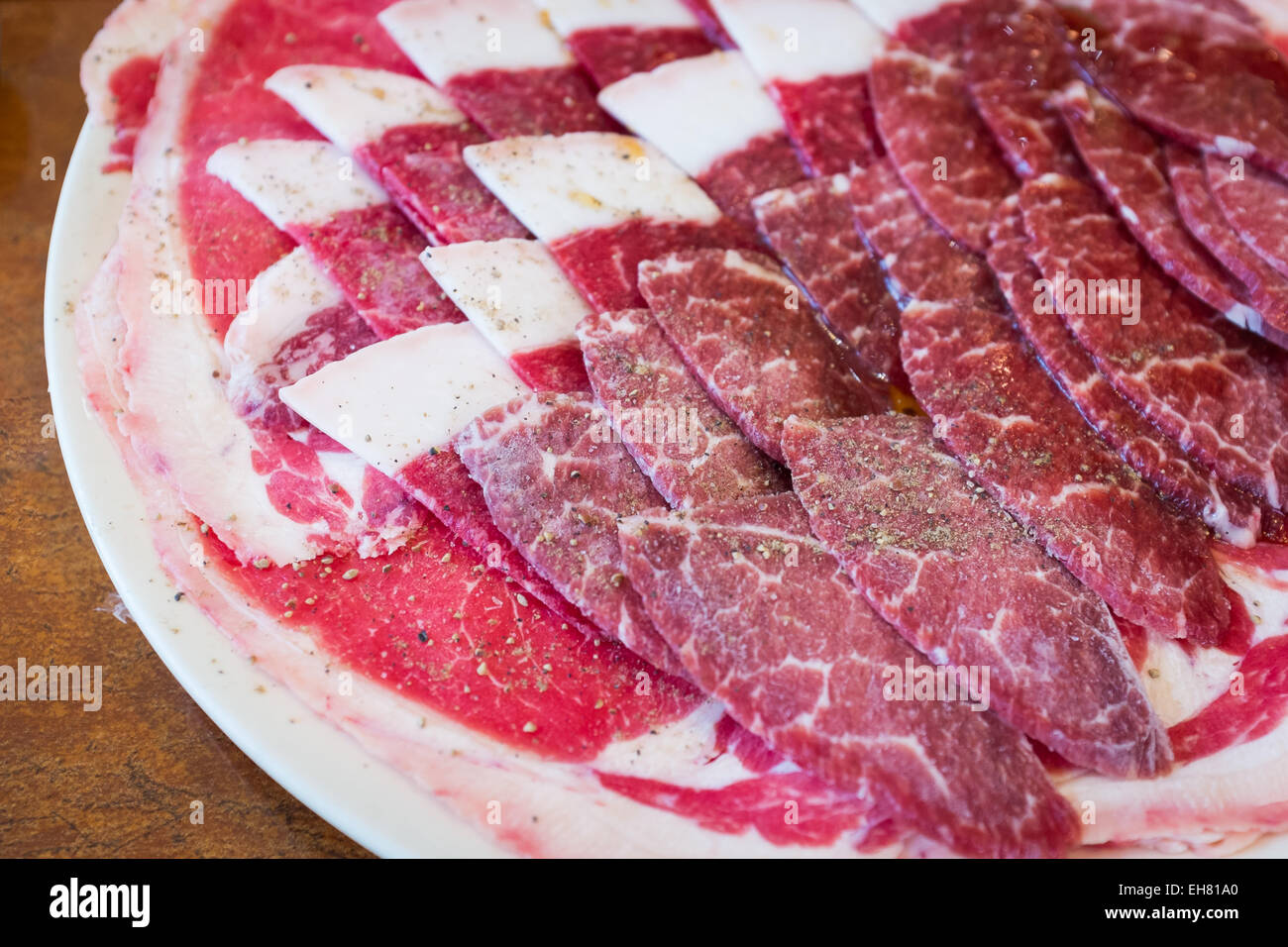 Rindfleisch auf weißem Teller, Salz, Pfeffer und Sauce auf Topping für BBQ Korea Food-Stil Stockfoto