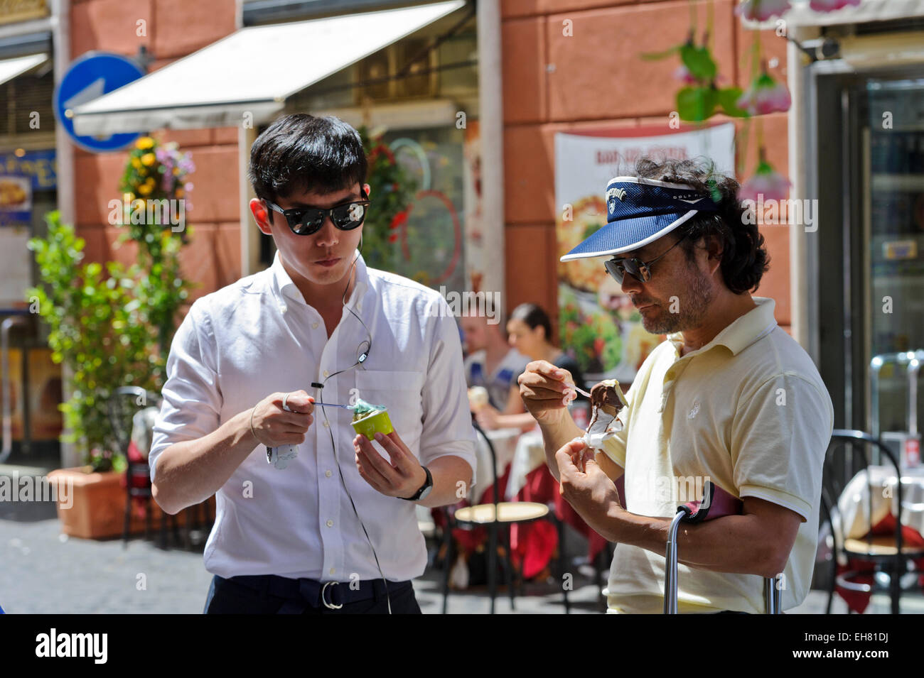 Zwei Männer essen Eis auf der Straße, Rom, Italien. Stockfoto