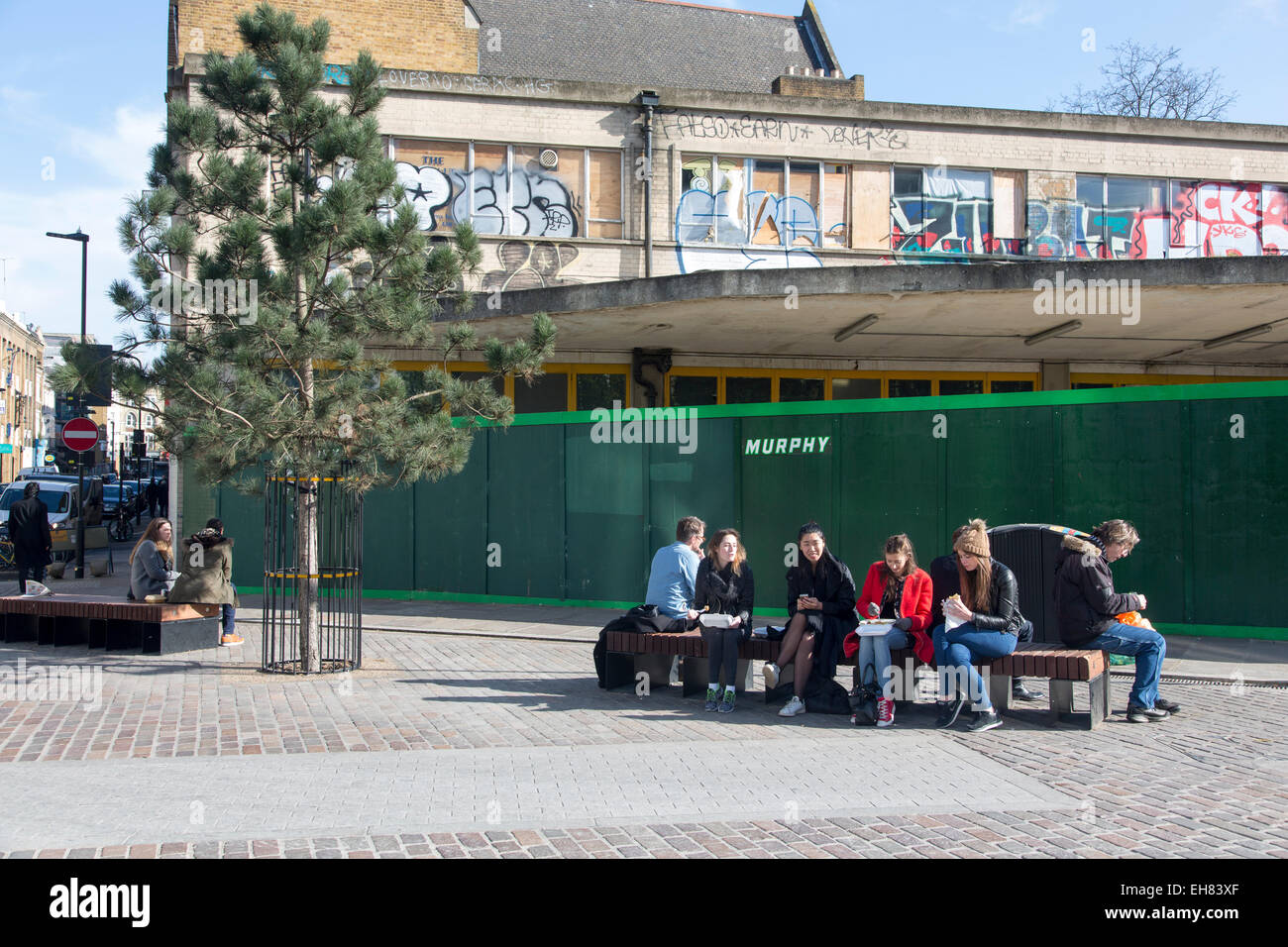 Menschen Essen vom Mittag Stall zu verkaufen Döner in Shoreditch, London, derzeit ein Ort der Kreativität junger Hipster. Stockfoto