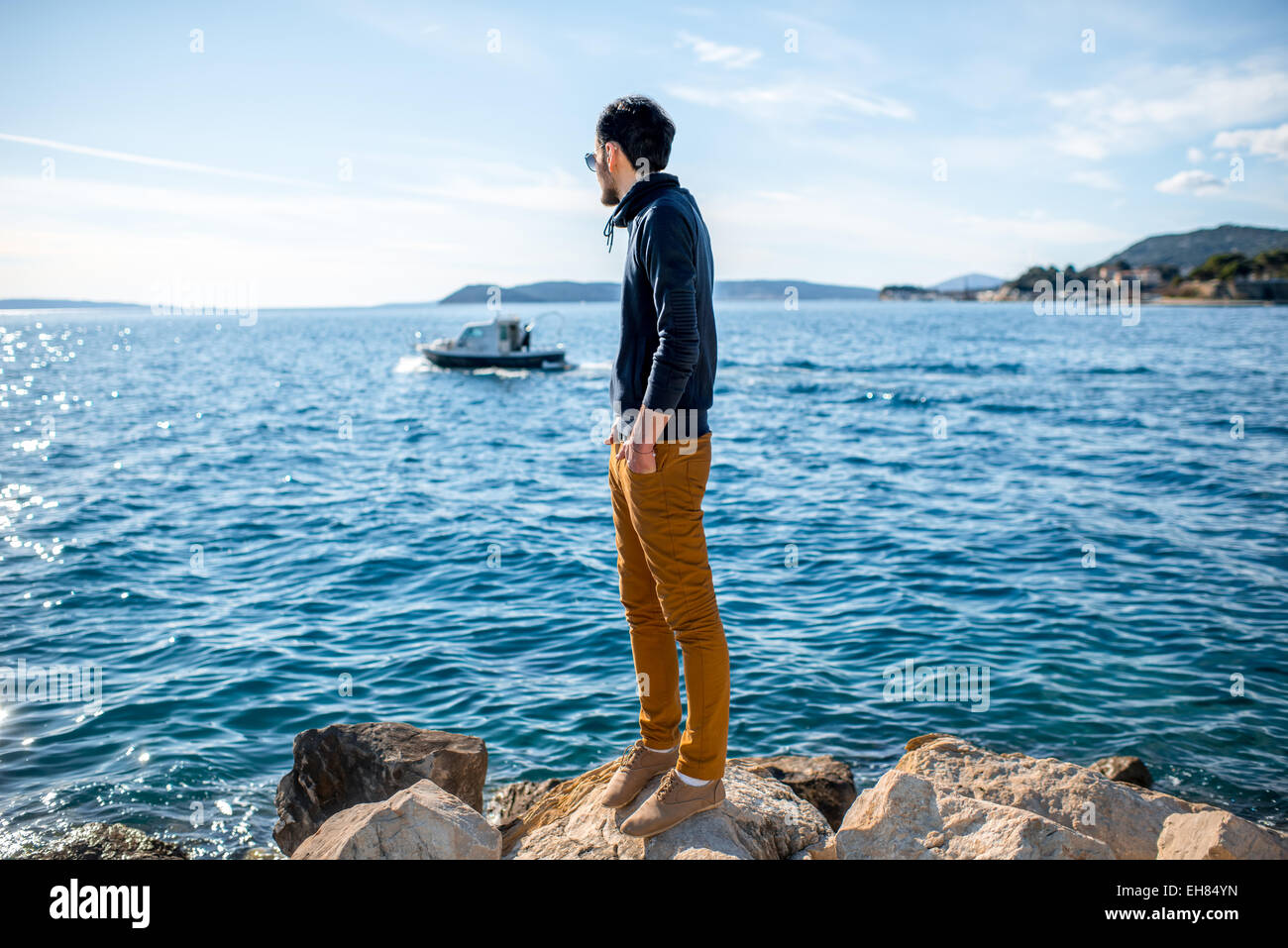 Mann beobachtet Boot auf dem Meer Stockfoto