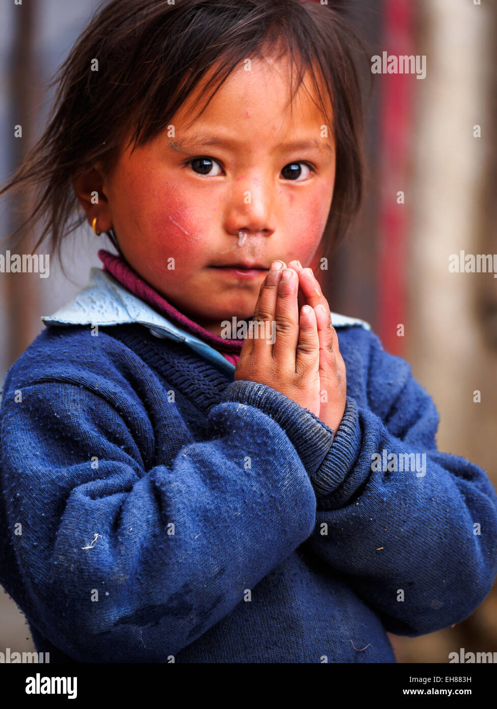 Junges Mädchen in Lo Manthang, Mustang, Nepal legt ihre Hände in die Position "Namaste". Konzentrieren Sie sich auf Händen. Stockfoto