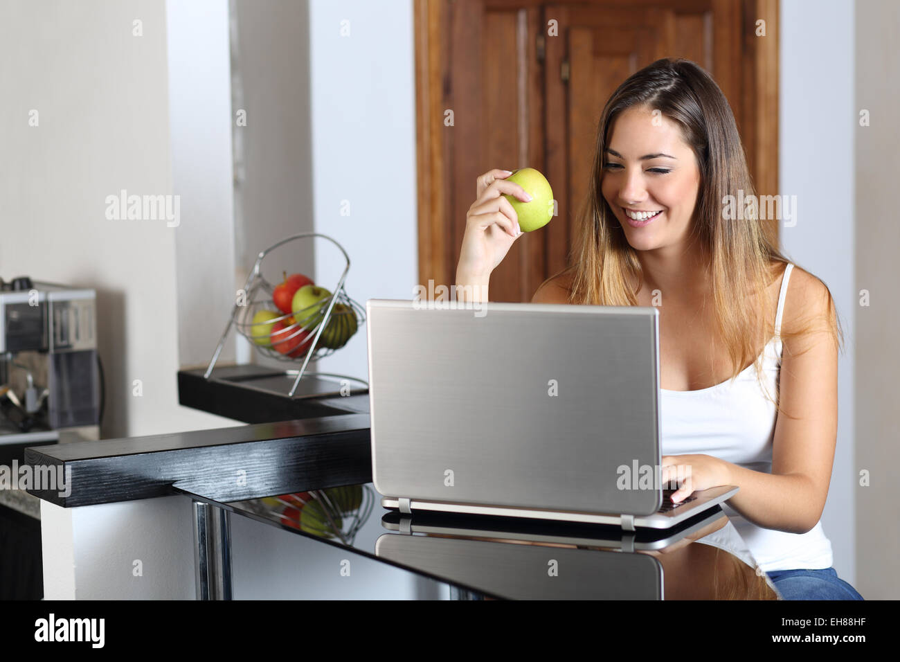 Unternehmer-Frau einen Laptop Surfen und Essen zu Hause in der Küche Stockfoto