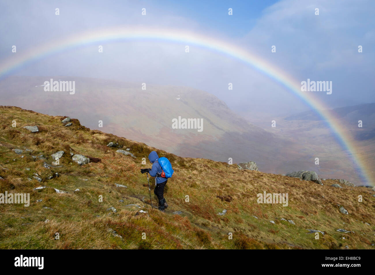 Wanderer, Wandern in nassem Wetter mit einem Regenbogen am Stift yr Helgi Du in Carneddau Berge von Snowdonia National Park, North Wales, UK Stockfoto