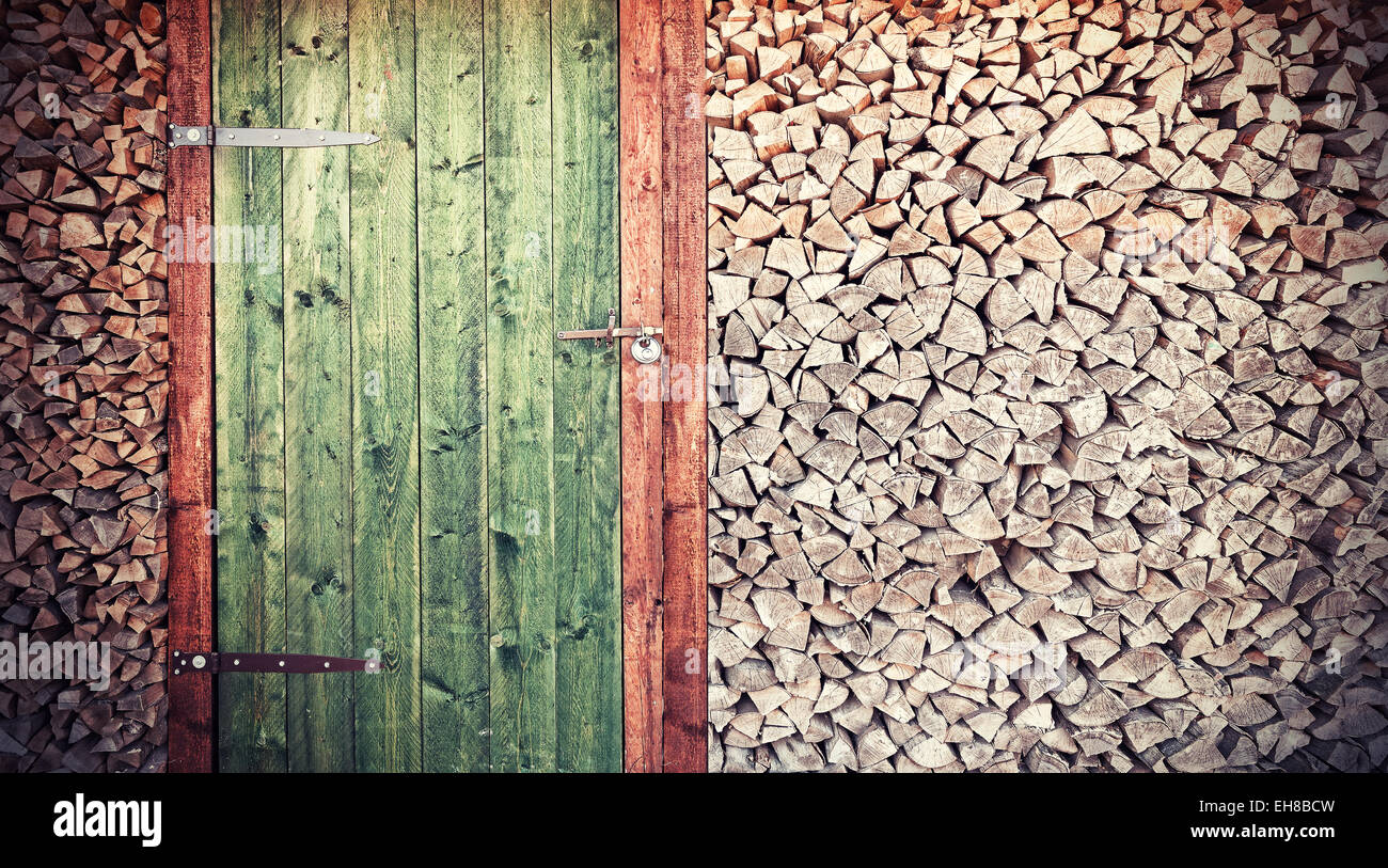 Retro-Foto von alten rustikalen Holztür mit Brennholz. Stockfoto