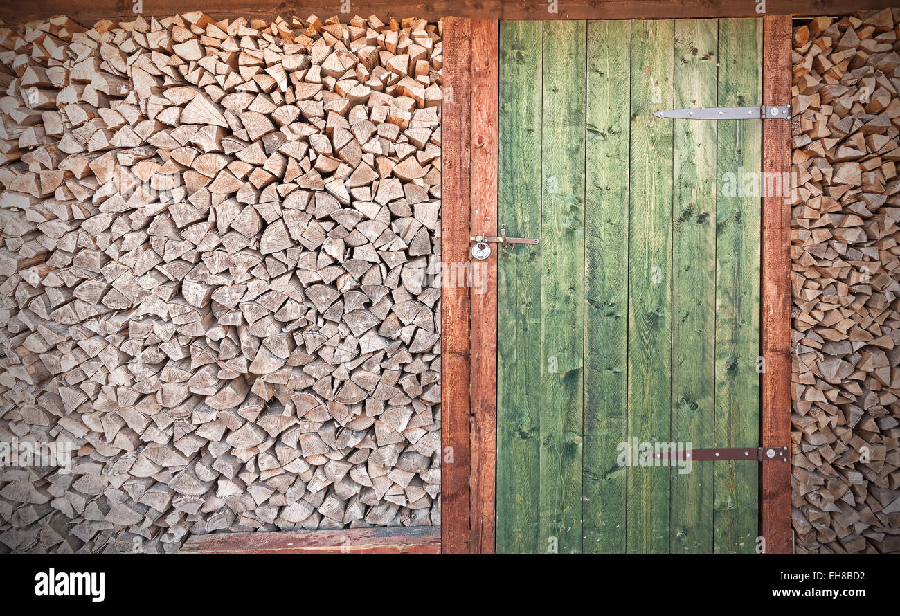 Retro-Foto von alten rustikalen Holztür mit Brennholz. Stockfoto