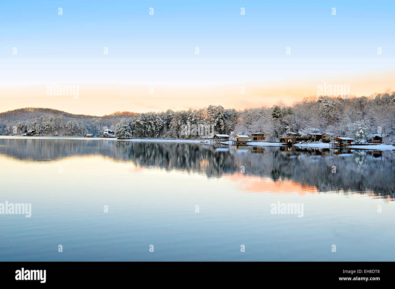 Winterlandschaft am Morgen auf See und Berge, mit Spiegelbild im Wasser und einer leichten Abstauben von Schnee. Stockfoto