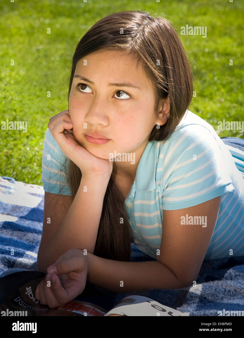 Junge Mensch Menschen Vietnamesische/Kaukasische Mädchen 11-13 Jahre alten Festlegung auf Magen auf Gras meditieren Vorderansicht Tween tweens HERR © Myrleen Pearson Stockfoto