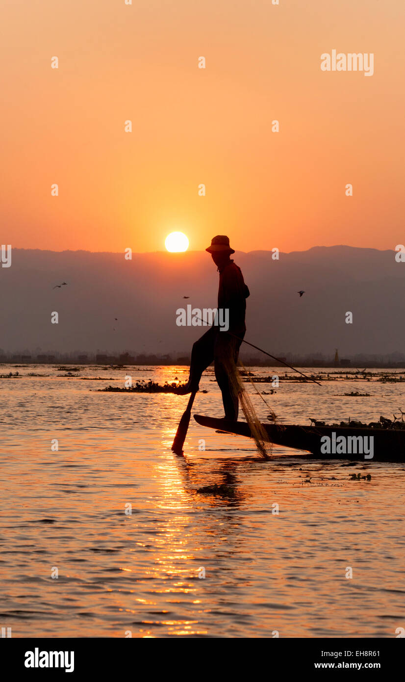 Ein einzelnes Bein Rudern Fischer bei Sonnenuntergang; Inle-See, Myanmar (Burma), Asien Stockfoto